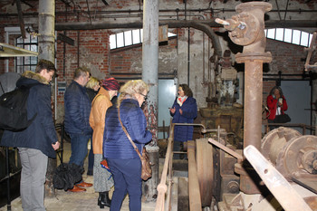 Besuchergruppe in Pressmaschinenraum einer Kohlebrikettfabrik